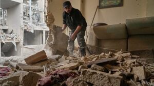 Lakók takarítják a romokat a csapásban megrongált dél-teheráni házaknál