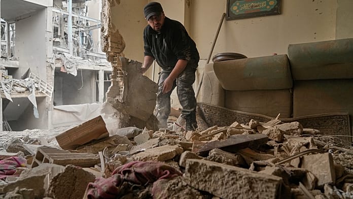 Lakók takarítják a romokat a csapásban megrongált dél-teheráni házaknál