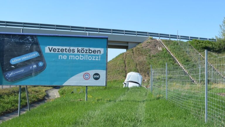 Földbe állt egy autó, a „vezetés közben ne mobilozz” tábla mellett
